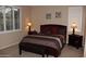 Bedroom with a dark wood bed frame and nightstands at 9219 S 185Th Ave, Goodyear, AZ 85338