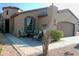 Tan house with brown garage door, sitting area, and desert landscaping at 9219 S 185Th Ave, Goodyear, AZ 85338