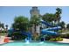 Community water park featuring a lighthouse tower and waterslide surrounded by palms and manicured landscaping at 9219 S 185Th Ave, Goodyear, AZ 85338