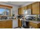 Kitchen with wood cabinets, stove, and dishwasher at 1272 E Dust Devil Dr, San Tan Valley, AZ 85143