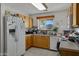 Galley-style kitchen with refrigerator, stove, and ample counter space at 1272 E Dust Devil Dr, San Tan Valley, AZ 85143