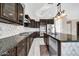 Modern kitchen with dark cabinetry, granite counters, and stainless steel appliances at 13611 W Merrell St, Avondale, AZ 85392