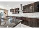 Modern kitchen with dark wood cabinets and granite countertops at 13611 W Merrell St, Avondale, AZ 85392