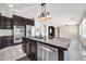 Modern kitchen with dark cabinetry, granite counters, and stainless steel appliances at 13611 W Merrell St, Avondale, AZ 85392