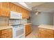 Bright kitchen with oak cabinets, white appliances, and tile flooring at 14103 W Casa Linda Dr, Sun City West, AZ 85375