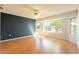 Living room with wood flooring, large window, and accent wall at 14103 W Casa Linda Dr, Sun City West, AZ 85375