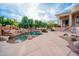 Beautiful pool with rock waterfall feature, desert landscaping, and outdoor kitchen area, perfect for entertaining guests at 15701 E Greystone Dr, Fountain Hills, AZ 85268