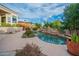 Inviting pool with a natural rock waterfall feature, mature landscaping, and blue skies overhead creating a serene outdoor oasis at 15701 E Greystone Dr, Fountain Hills, AZ 85268