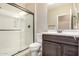 Bathroom with dark wood vanity, sliding glass shower, and toilet at 15913 S 11Th Way, Phoenix, AZ 85048