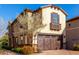 Tan three story home with a brown garage door and landscaping at 15913 S 11Th Way, Phoenix, AZ 85048