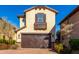 Tan three-story home with brown garage doors, shutters, and balcony at 15913 S 11Th Way, Phoenix, AZ 85048