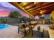 Relaxing covered patio with seating area, adjacent to a sparkling pool at 1625 W Cool Water Way, San Tan Valley, AZ 85144