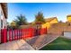 Landscaped backyard with red fence and garden area at 1625 W Cool Water Way, San Tan Valley, AZ 85144