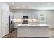 Modern kitchen with white cabinets, quartz countertops, and stainless steel appliances at 17741 W Mission Ln, Waddell, AZ 85355