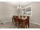 Formal dining room with wood table and chairs, chandelier, and large window at 18610 W Alice Ave, Waddell, AZ 85355