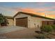 Single story home with brown garage door and landscaping at 18610 W Alice Ave, Waddell, AZ 85355