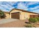 Single story home with brown garage door and landscaping at 18610 W Alice Ave, Waddell, AZ 85355