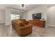 Comfortable living room featuring leather sofa, large TV, and ceiling fan at 18610 W Alice Ave, Waddell, AZ 85355