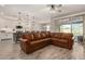 Spacious living room with leather sectional sofa and wood media console at 18610 W Alice Ave, Waddell, AZ 85355