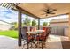 Covered patio with dining table and ceiling fan at 18610 W Alice Ave, Waddell, AZ 85355