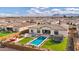 Aerial view of backyard featuring a sparkling pool, trampoline, and a cozy outdoor living space at 20456 E Camina Buena Vis, Queen Creek, AZ 85142