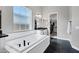 Bright bathroom featuring a soaking tub, black floors, and a walk-in closet at 20456 E Camina Buena Vis, Queen Creek, AZ 85142