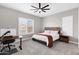 Neutral bedroom offers a ceiling fan, plantation shutters, and desk area at 20456 E Camina Buena Vis, Queen Creek, AZ 85142