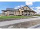 This clubhouse offers a welcoming entrance with a covered porch, seating, and lush green surroundings at 20456 E Camina Buena Vis, Queen Creek, AZ 85142