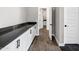 Hallway with white cabinets, black hardware, and wood floors at 20456 E Camina Buena Vis, Queen Creek, AZ 85142