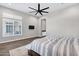 Spacious main bedroom featuring wood floors, a modern ceiling fan, and bright window at 20456 E Camina Buena Vis, Queen Creek, AZ 85142