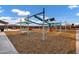 Community playground with swings, slides and climbing apparatus for outdoor enjoyment on wood chip groundcover at 20456 E Camina Buena Vis, Queen Creek, AZ 85142