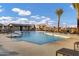 Community pool with ample lounge chairs, palm trees, umbrellas, and pool house at 20456 E Camina Buena Vis, Queen Creek, AZ 85142