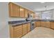 Modern kitchen featuring wood cabinets, granite countertops, and stainless steel appliances at 20902 N 36Th Pl, Phoenix, AZ 85050