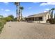 Wide view of the backyard with palm trees, patio, cactus and desert landscaping at 23114 N 146Th Dr, Sun City West, AZ 85375