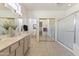 Bright, spacious bathroom featuring double sinks, a glass shower, and a toilet in an adjacent room at 23114 N 146Th Dr, Sun City West, AZ 85375