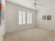 Bright bedroom features a ceiling fan, carpeted floor, and large windows with plantation shutters at 23114 N 146Th Dr, Sun City West, AZ 85375