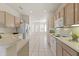 Bright kitchen features white appliances, light wood cabinets, and an open design leading to the dining area at 23114 N 146Th Dr, Sun City West, AZ 85375