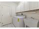 Well-lit laundry room featuring white cabinets, tile floor, sink, and washer and dryer at 23114 N 146Th Dr, Sun City West, AZ 85375