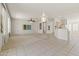 Spacious living room with tile and carpet flooring, a ceiling fan, and a view to the adjacent kitchen at 23114 N 146Th Dr, Sun City West, AZ 85375