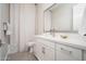 Bathroom with a gray framed mirror, white cabinets, and shower at 23448 N 76Th Pl, Scottsdale, AZ 85255