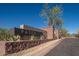 Community sign for Paseo neighborhood entrance featuring stone brick wall, landscaping, and gated entry at 23448 N 76Th Pl, Scottsdale, AZ 85255