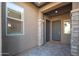 Covered front entryway with a welcome mat and decorative stone accents at 23448 N 76Th Pl, Scottsdale, AZ 85255