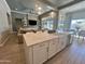 Modern kitchen with a large island, farm sink, and pendant lighting, seamlessly blending into the dining and living areas at 23448 N 76Th Pl, Scottsdale, AZ 85255