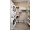 Convenient laundry area with stacked washer and dryer units and storage shelves for organization at 23448 N 76Th Pl, Scottsdale, AZ 85255