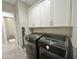 Modern laundry room with front-load washer and dryer, white cabinets for storage, and neutral walls at 23448 N 76Th Pl, Scottsdale, AZ 85255