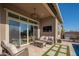 Inviting outdoor patio with comfortable seating, outdoor kitchen, mounted television, and custom designed turf at 23448 N 76Th Pl, Scottsdale, AZ 85255