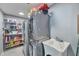 Laundry room with washer, dryer, shelving, and a utility sink at 2641 W Wethersfield Rd, Phoenix, AZ 85029