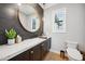 Elegant powder room with marble countertop, dark cabinets, modern fixtures, and a round gold mirror at 2752 E Pelican Ct, Gilbert, AZ 85297