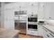 Modern kitchen design with white cabinets, stainless steel refrigerator and oven, and marble countertops at 2752 E Pelican Ct, Gilbert, AZ 85297