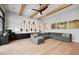 Bright living room with wooden beams, a large gray sectional, custom built-ins, and unique wall decor at 2752 E Pelican Ct, Gilbert, AZ 85297